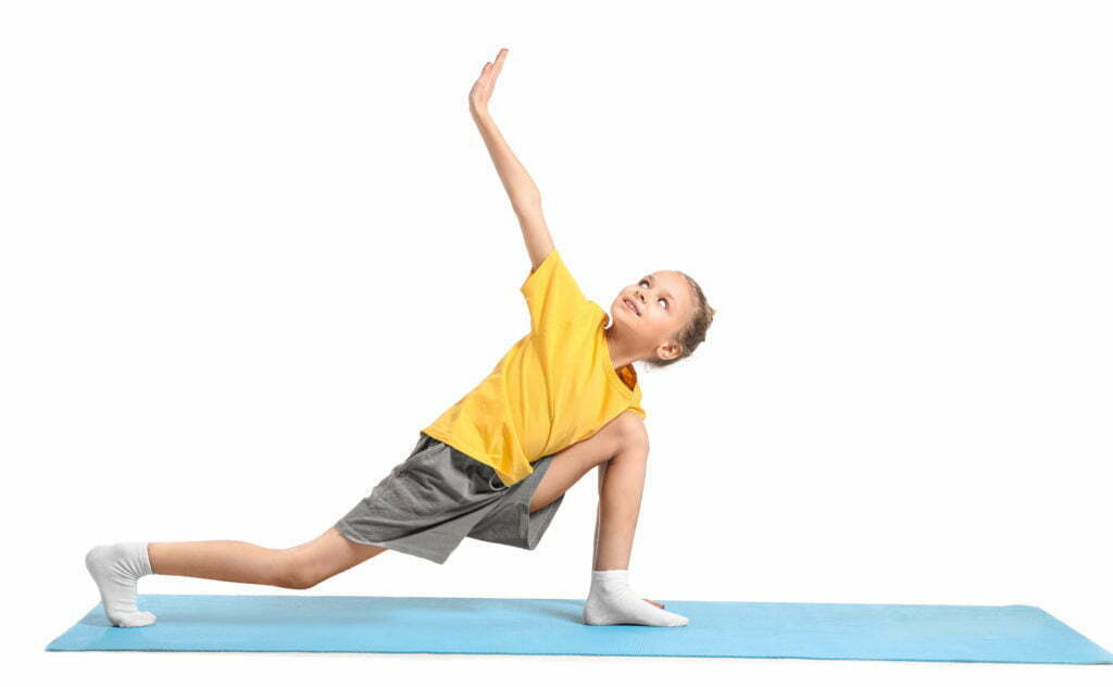 Photo d'une petite fille effectuant un étirement yoga sur un tapis