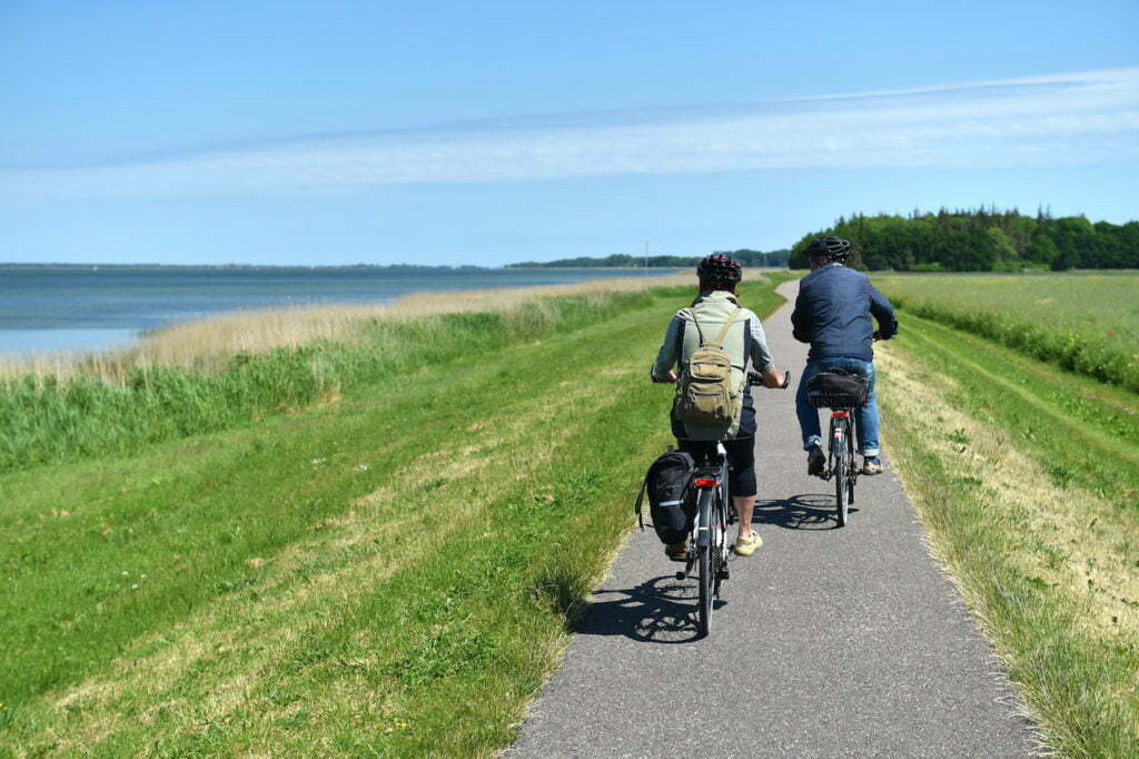 Photo de 2 cyclistes sur une piste cyclable le long de la mer