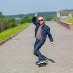 Photo drôle d'un homme senior faisant du skateboard très à l'aise